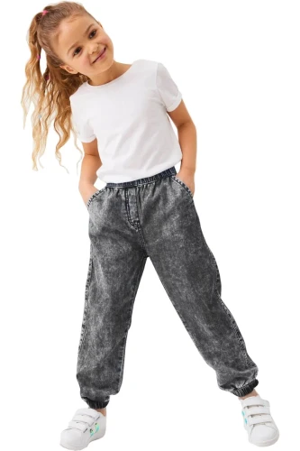 next-grafitowe-dziewczece-spodnie-joggery-modelka-przod.webp