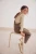 next-bezowy-sweter-golf-z-falbanka-prazkowany-modelka-siedzaca.webp