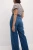 M&S-ciemnce-jeansy-spodnie-wilde-szerokie-nogawki-modelka-tyl.webp