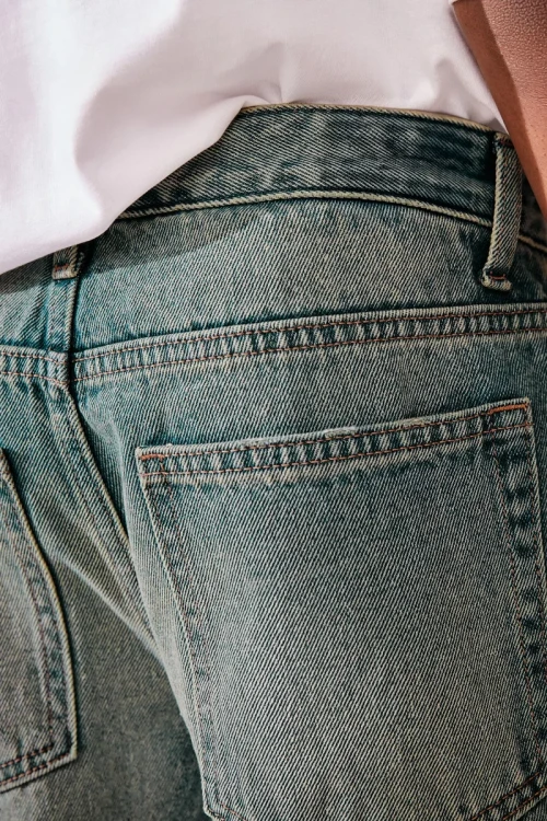 Next-chlopiece-jeansowe-spodnie-jeans-szeroka-nogawka-model-zblizenie.webp