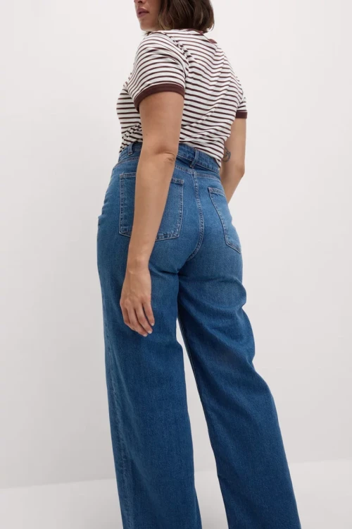 M&S-ciemne-jeansowe-spodnie-szeroka-nogawka-jeans-modelka-tyl.webp