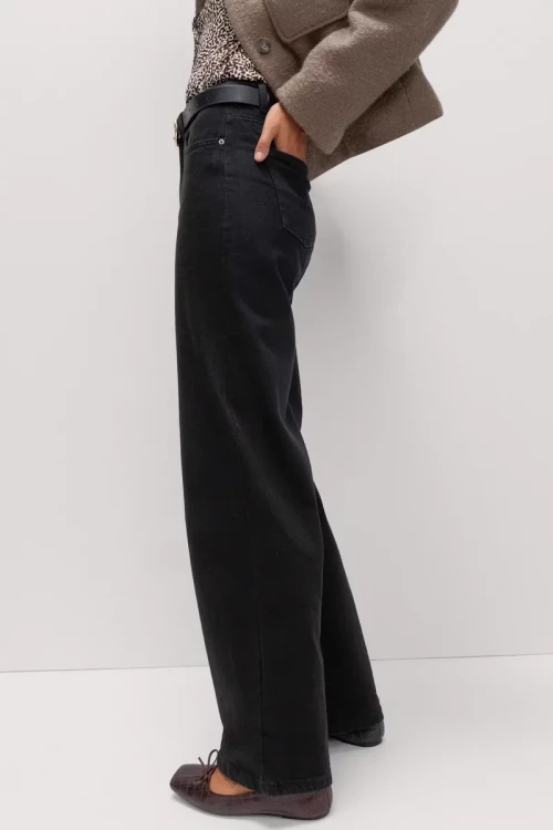 M&S-czarne-jeansowe-spodnie-szeroka-nogawka-jeans-modelka-bok.webp