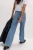 M&S-jasne-jeansowe-spodnie-szeroka-nogawka-jeans-modelka-tyl.webp