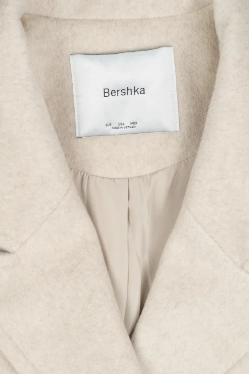 Bershka-bezowy-plaszcz-guziki-zblizenie.webp