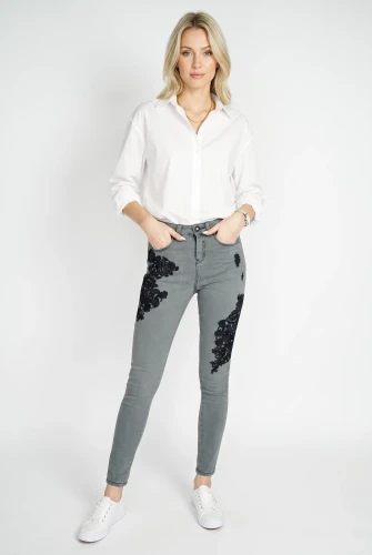 Primark-grafitowe-spodnie-jeansy-z-haftem-modelka-przod.webp