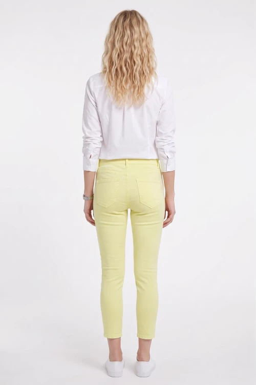 C&A-kanarkowe-spodnie-jeansy-crop-zamki-modelka-tyl.webp