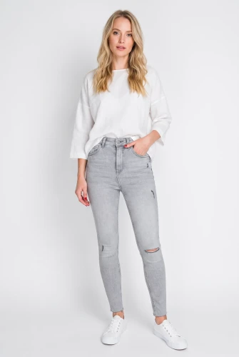 Primark-szare-spodnie-jeansy-z-przetarciami-modelka-przod.webp