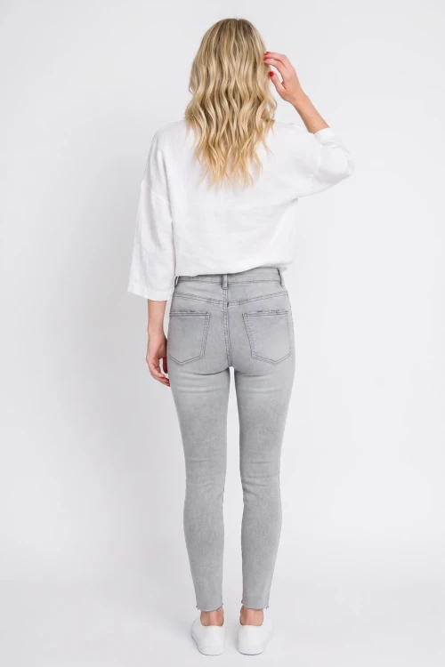 Primark-szare-spodnie-jeansy-z-przetarciami-modelka-tyl.webp