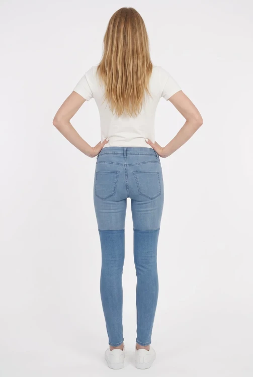 H&M-niebieskie-odcinane-spodnie-jeansy-modelka-tyl.webp