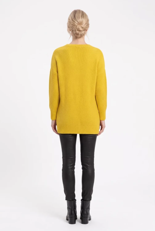 C&A-miodowy-dlugi-sweter-warkocze-modelka-tyl.webp