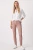 Primark-spodnie-pudrowy-roz-jeansy-zamki-modelka-przod.webp